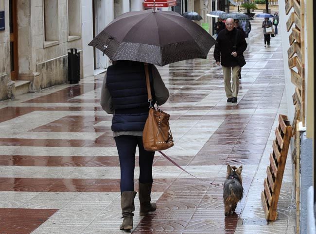 gente con paraguas en un dia de lluvia por el entro de mao